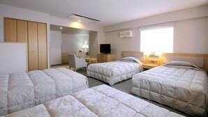 A hotel room with three beds, a desk, a television, and a window with curtains. - New Chiko Hotel (Hokkaido)