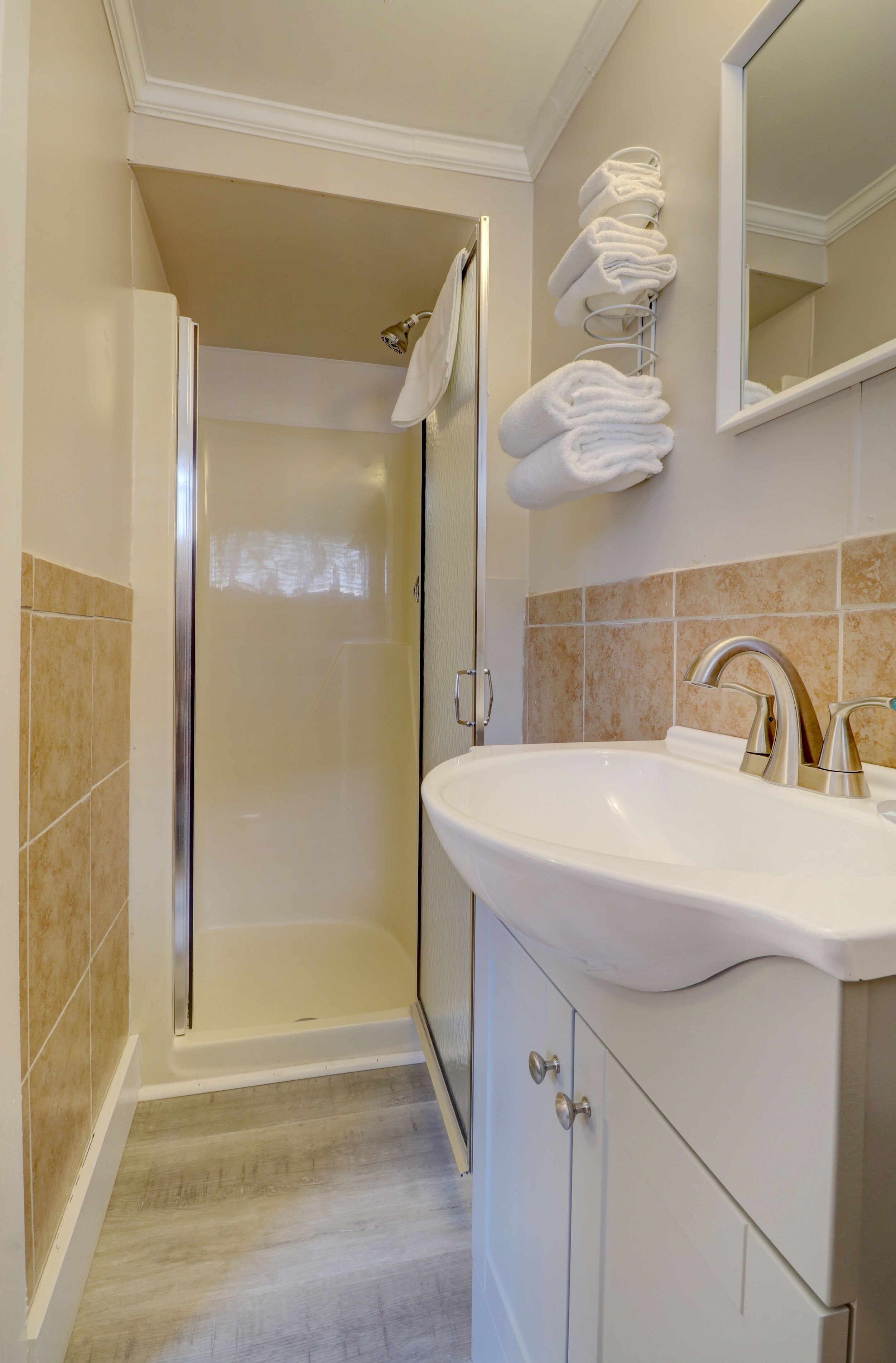 Un baño con lavamanos, espejo y ducha.