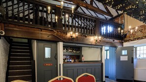A bar area with a staircase, wooden ceiling, and string lights. - Wheatsheaf Hotel by Chef and Brewer Collection (Basingstoke)