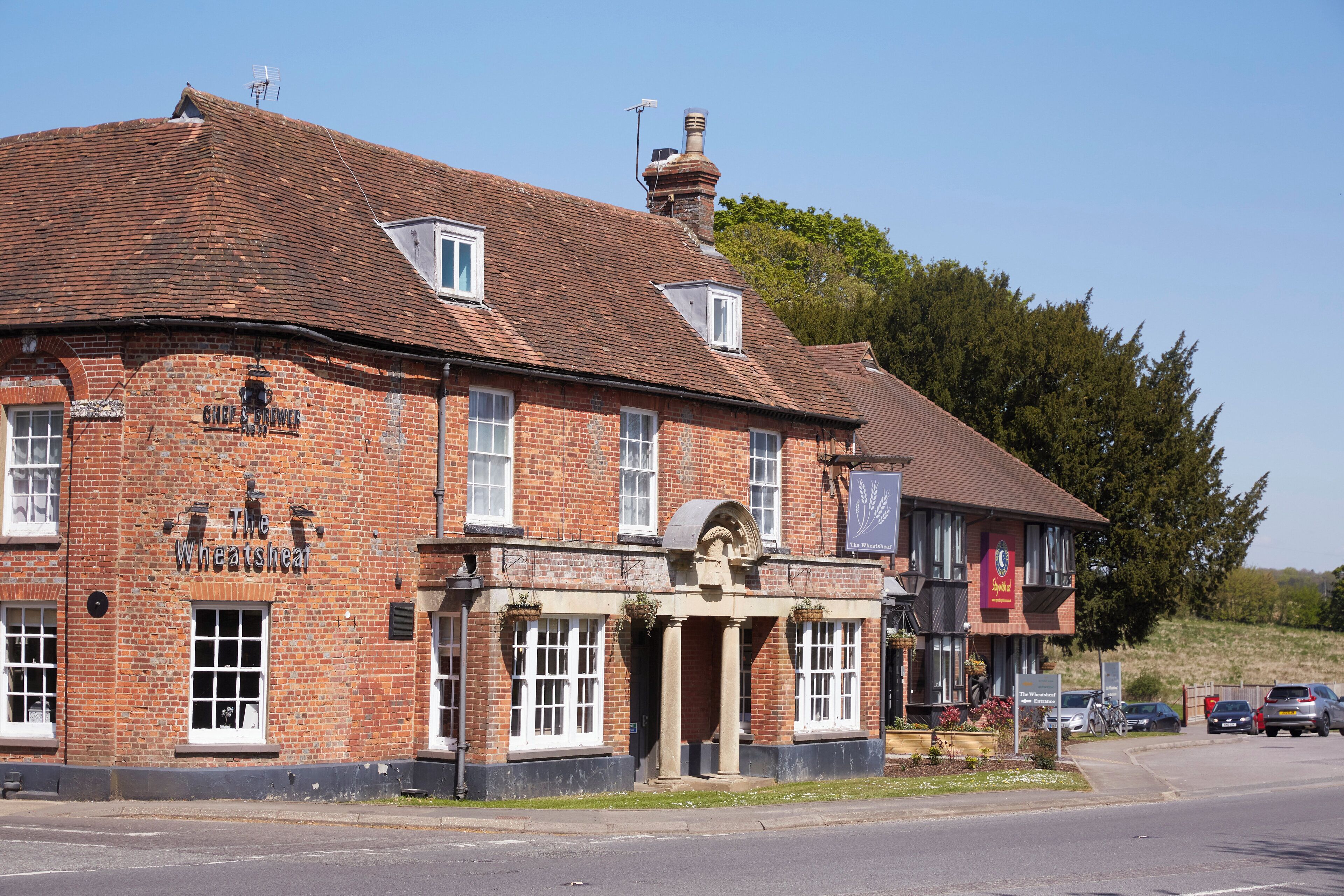 A traditional brick building with a sign reading 'The Wheatsheath.'