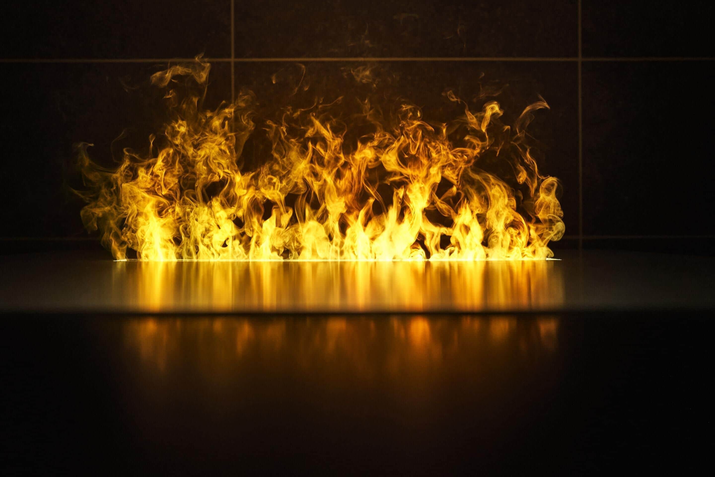 A fire with flames dancing against a dark background.