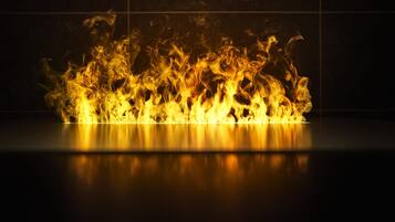 A fire with flames dancing against a dark background.