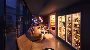 A modern lounge area with leather seating, a wine display, and a large TV screen. - Jaz in the City Stuttgart (Stuttgart)