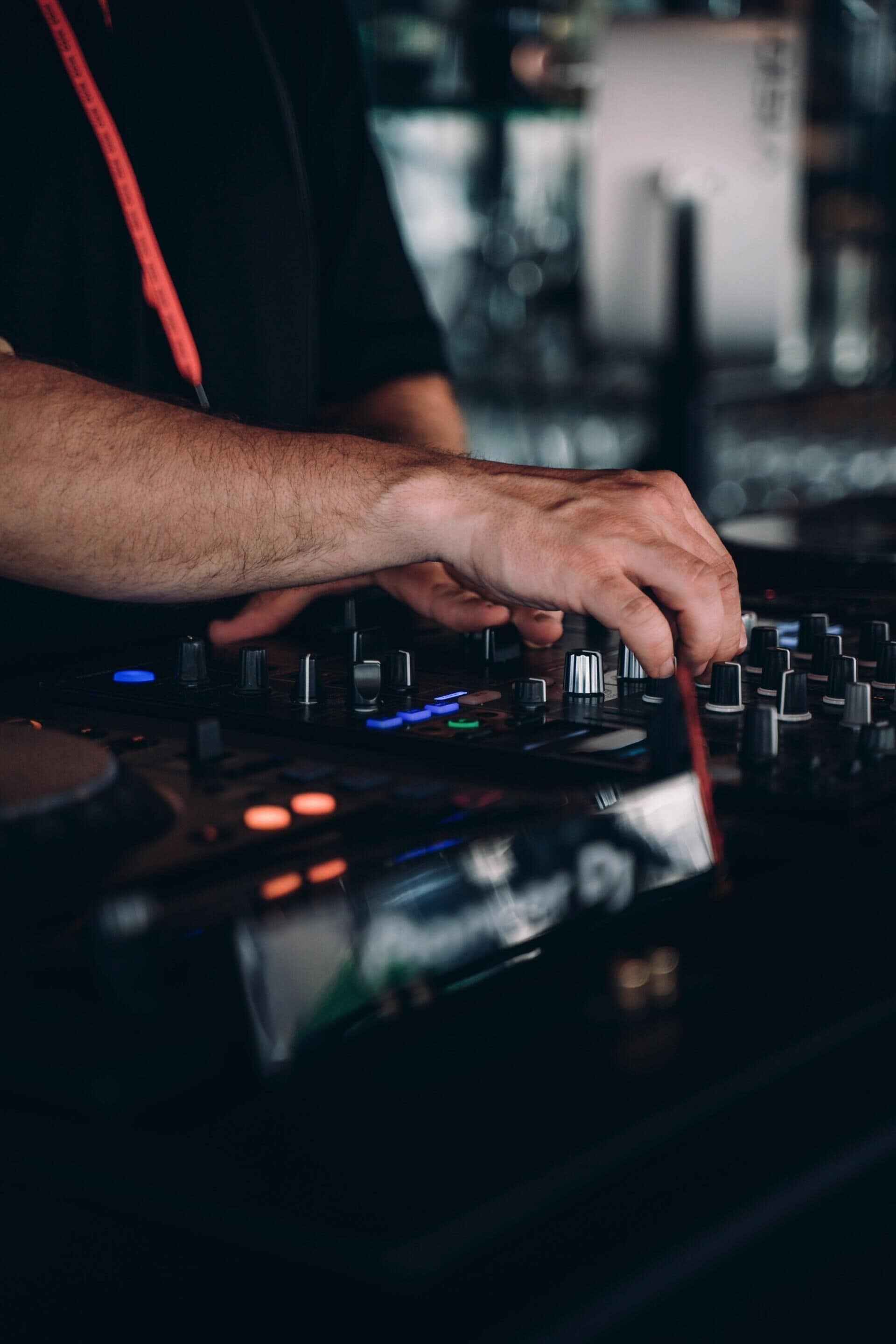 Ein Detailblick auf Hände, die DJ-Equipment bedienen.