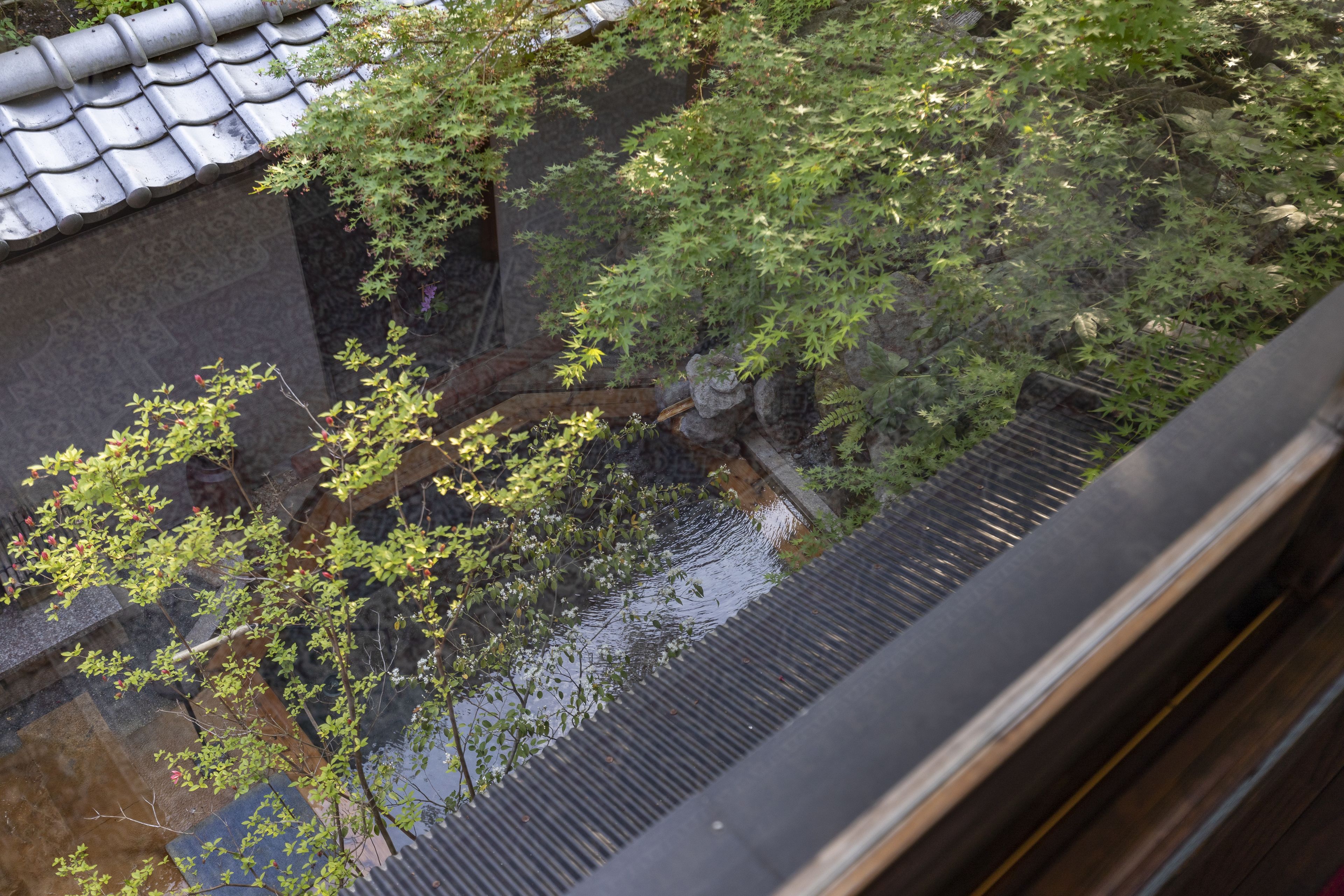 A traditional Japanese building with a tiled roof and a stone wall.