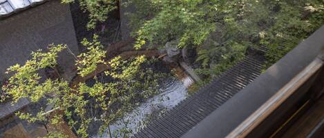 A traditional Japanese building with a tiled roof and a stone wall.