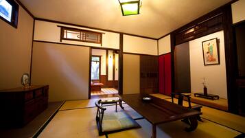 Una habitación japonesa tradicional con suelo de tatami, una mesa de madera baja y una puerta corredera.