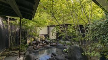 A traditional Japanese garden with a koi pond, rocks, and bamboo.
