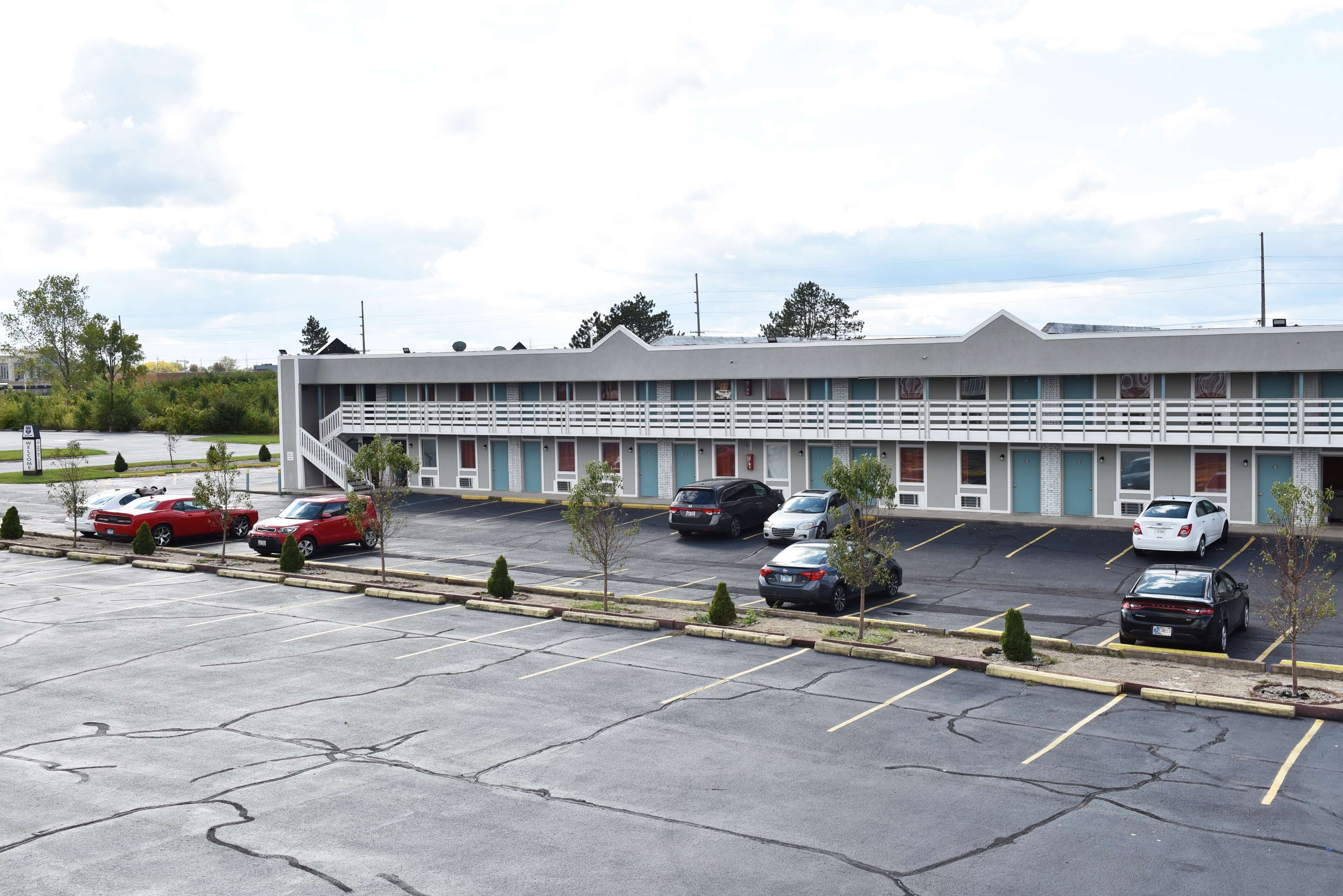 Ein Motel mit Parkplatz und mehreren Autos.