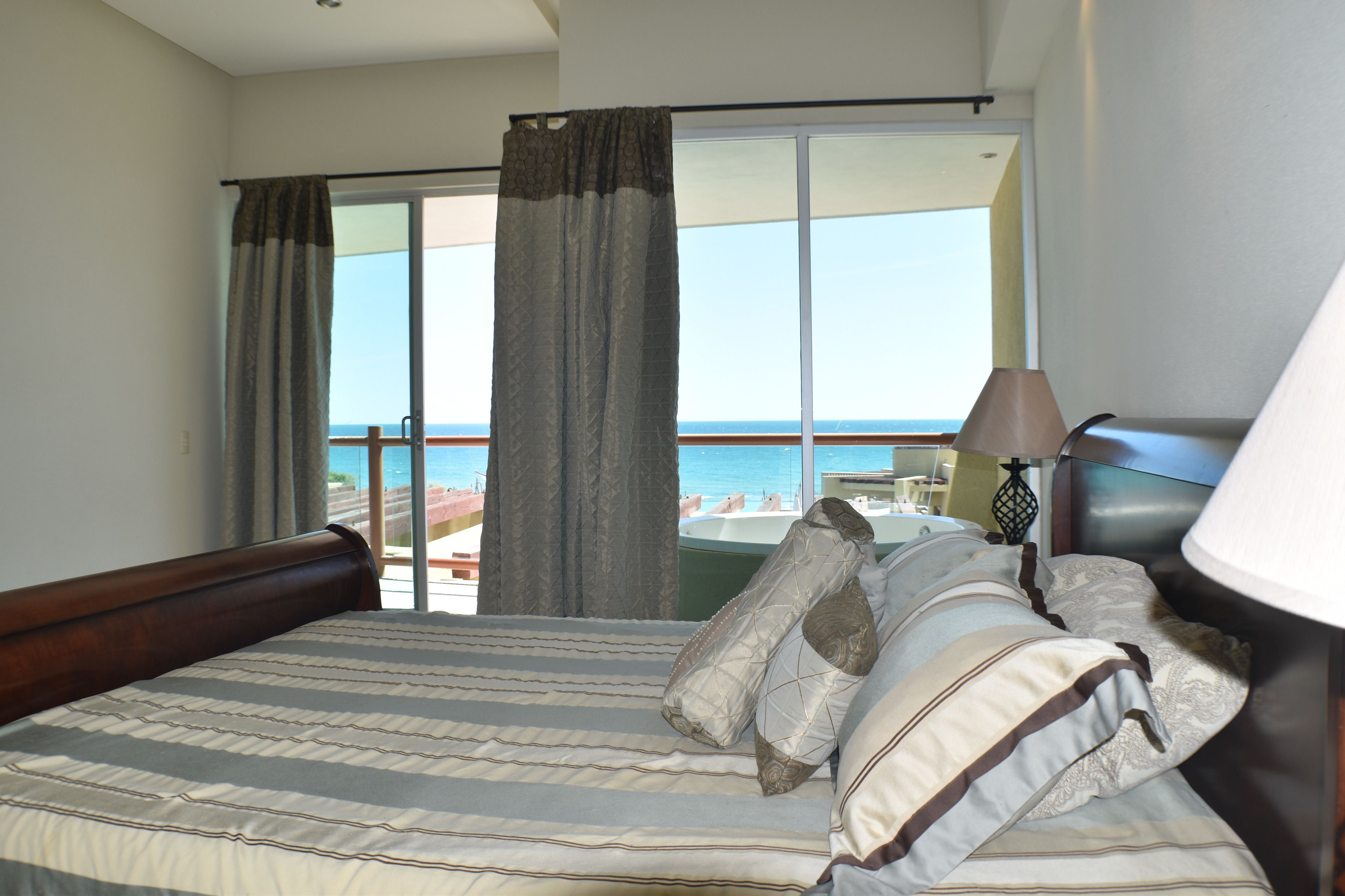 Une chambre d’hôtel avec un grand lit, une vue sur la mer et un balcon.