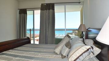 Une chambre d’hôtel avec un grand lit, une vue sur la mer et un balcon.