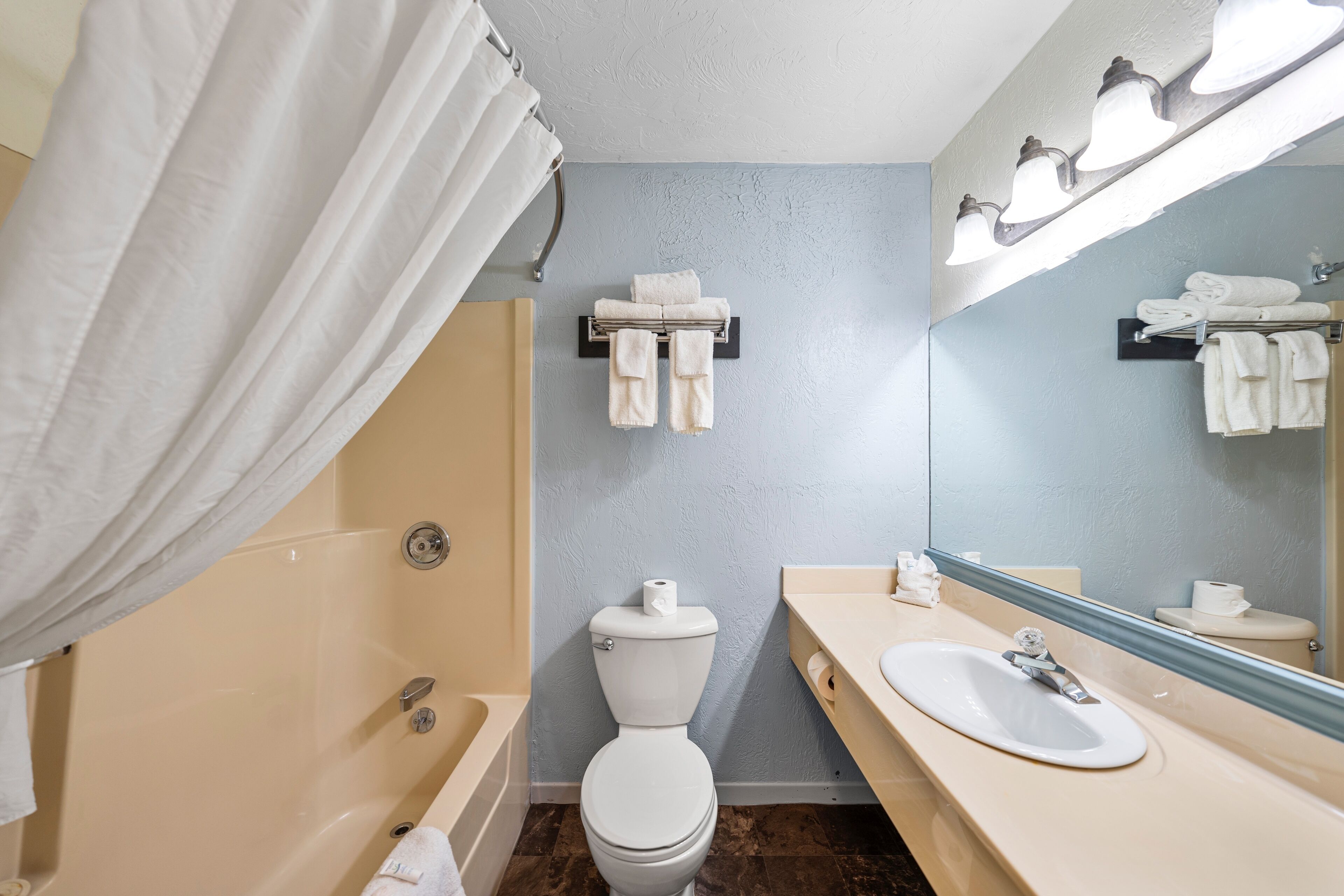 Une salle de bain équipée d’une baignoire, de toilettes, d’un lavabo et d’un porte-serviettes.
