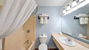 Une salle de bain équipée d’une baignoire, de toilettes, d’un lavabo et d’un porte-serviettes.
