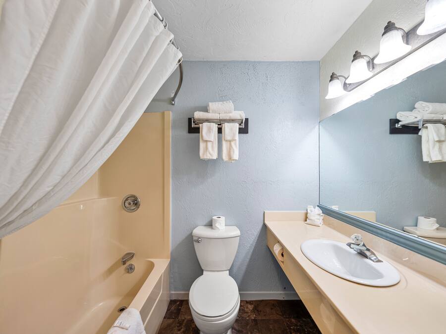 Une salle de bain équipée d’une baignoire, de toilettes, d’un lavabo et d’un porte-serviettes.
