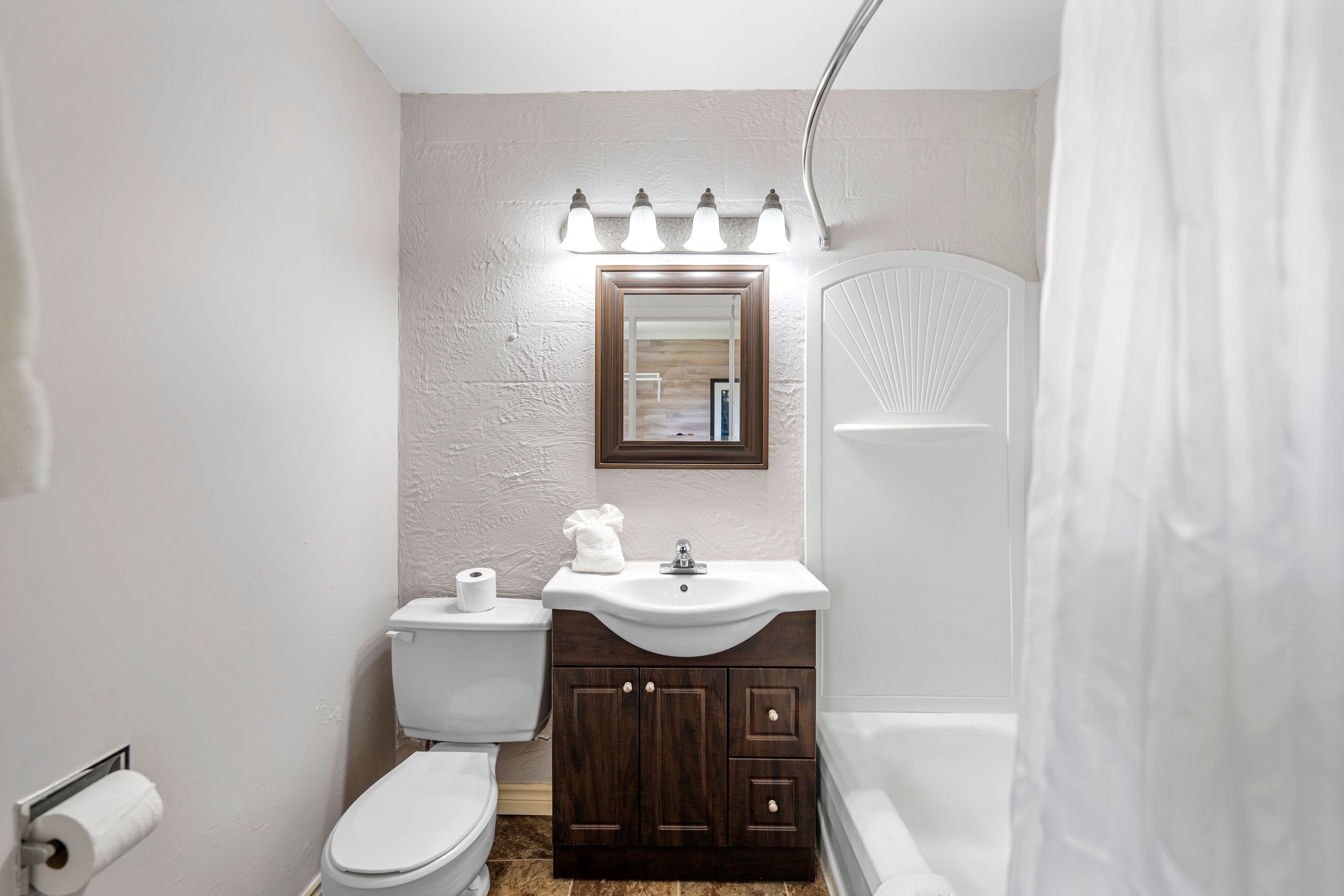 Une salle de bain avec des toilettes, un lavabo et une douche.