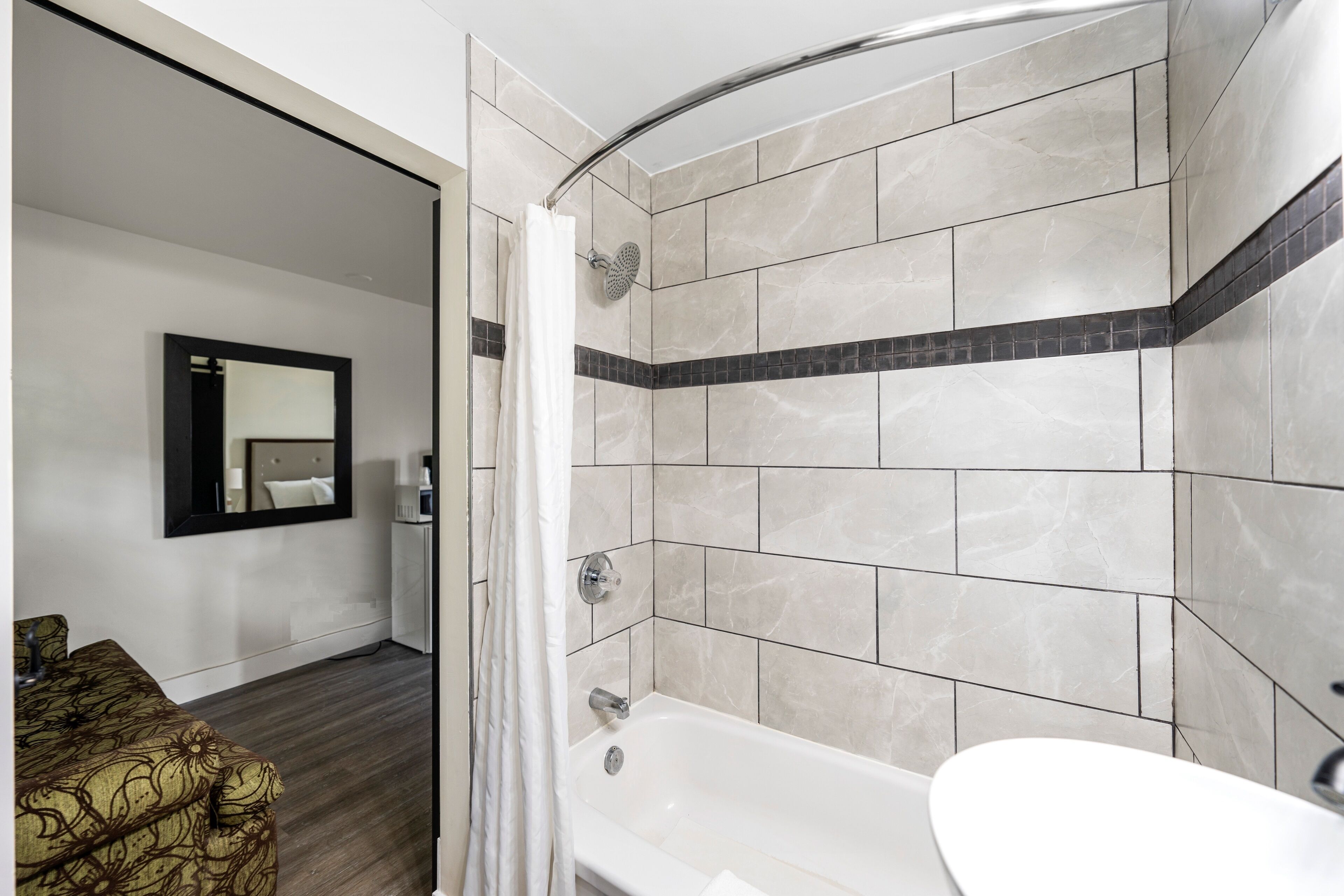 A modern bathroom with a bathtub, a shower, and a vanity.