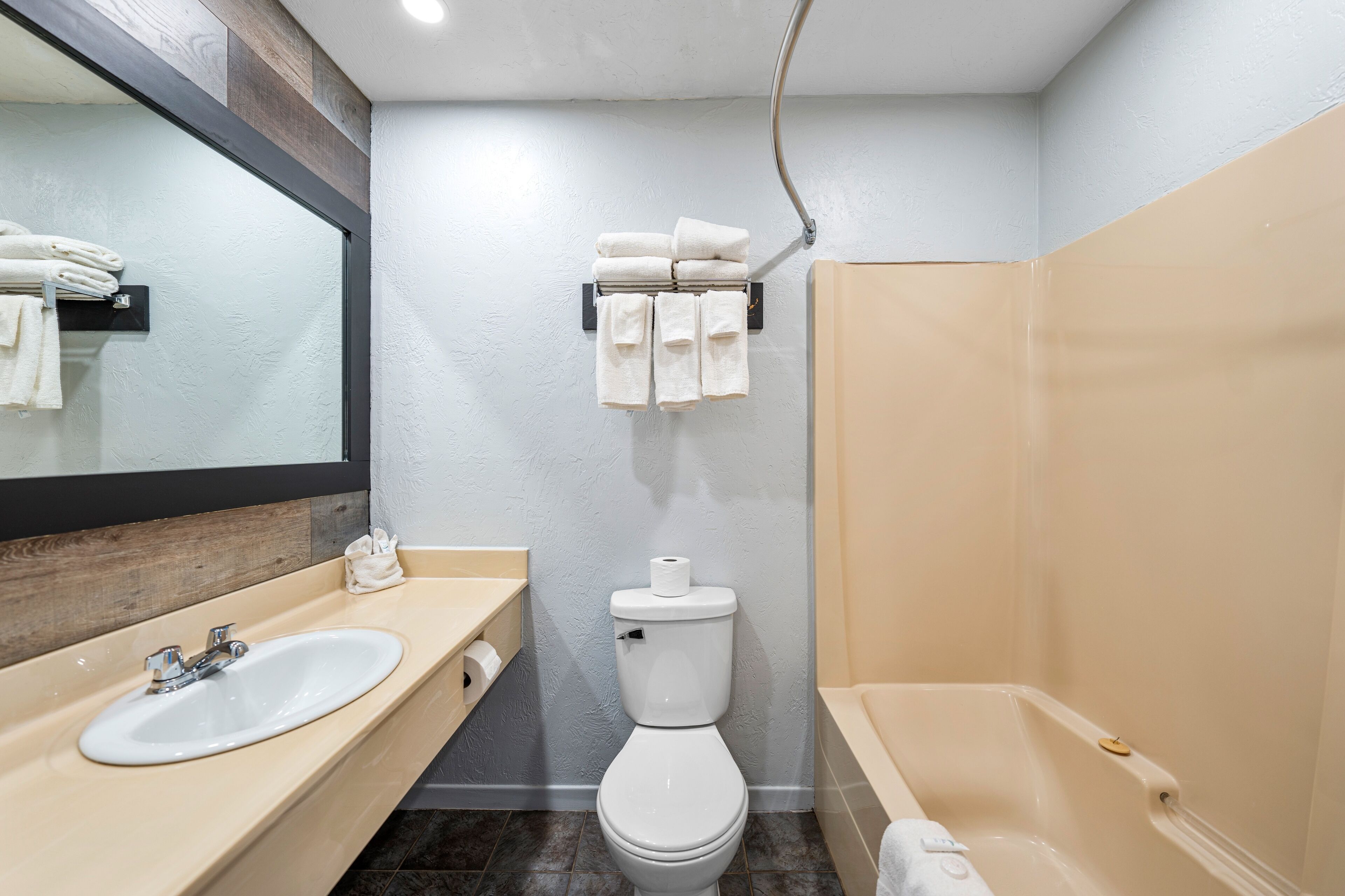 A modern bathroom with a sink, toilet, and bathtub.