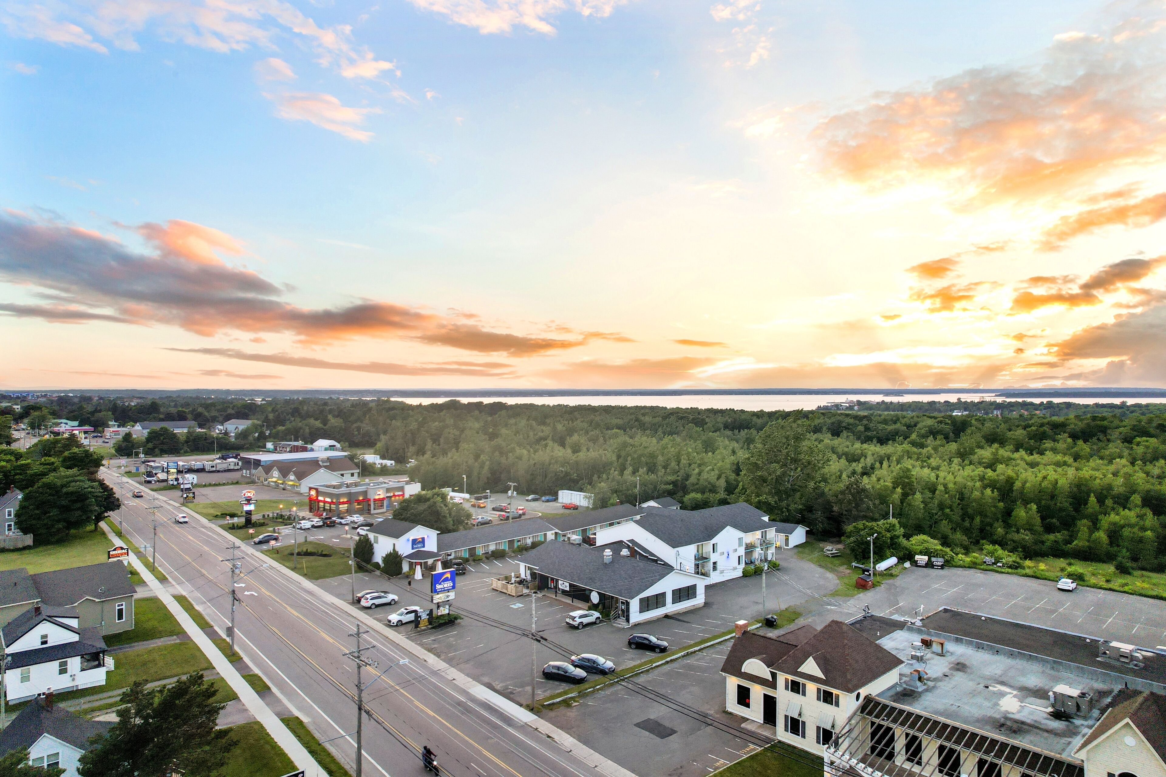 A commercial area with a gas station, parking lot, and buildings.