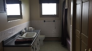 A small bathroom with a sink, toilet, and window. - Northwinds Motel (Northern Bruce Peninsula)