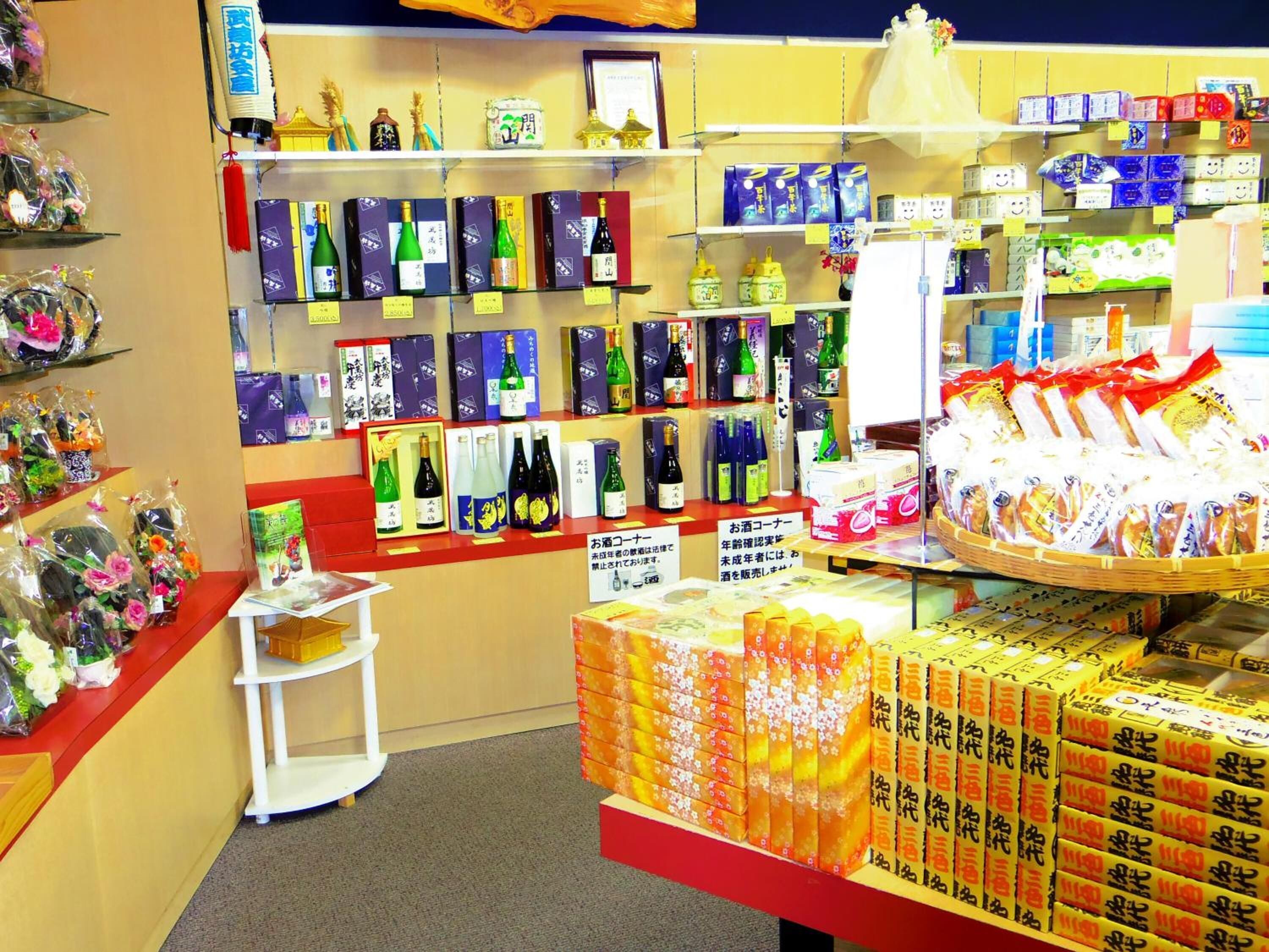 Un magasin dont les étagères sont remplies de divers produits, notamment des bouteilles et des boîtes, et où sont exposés des produits emballés.