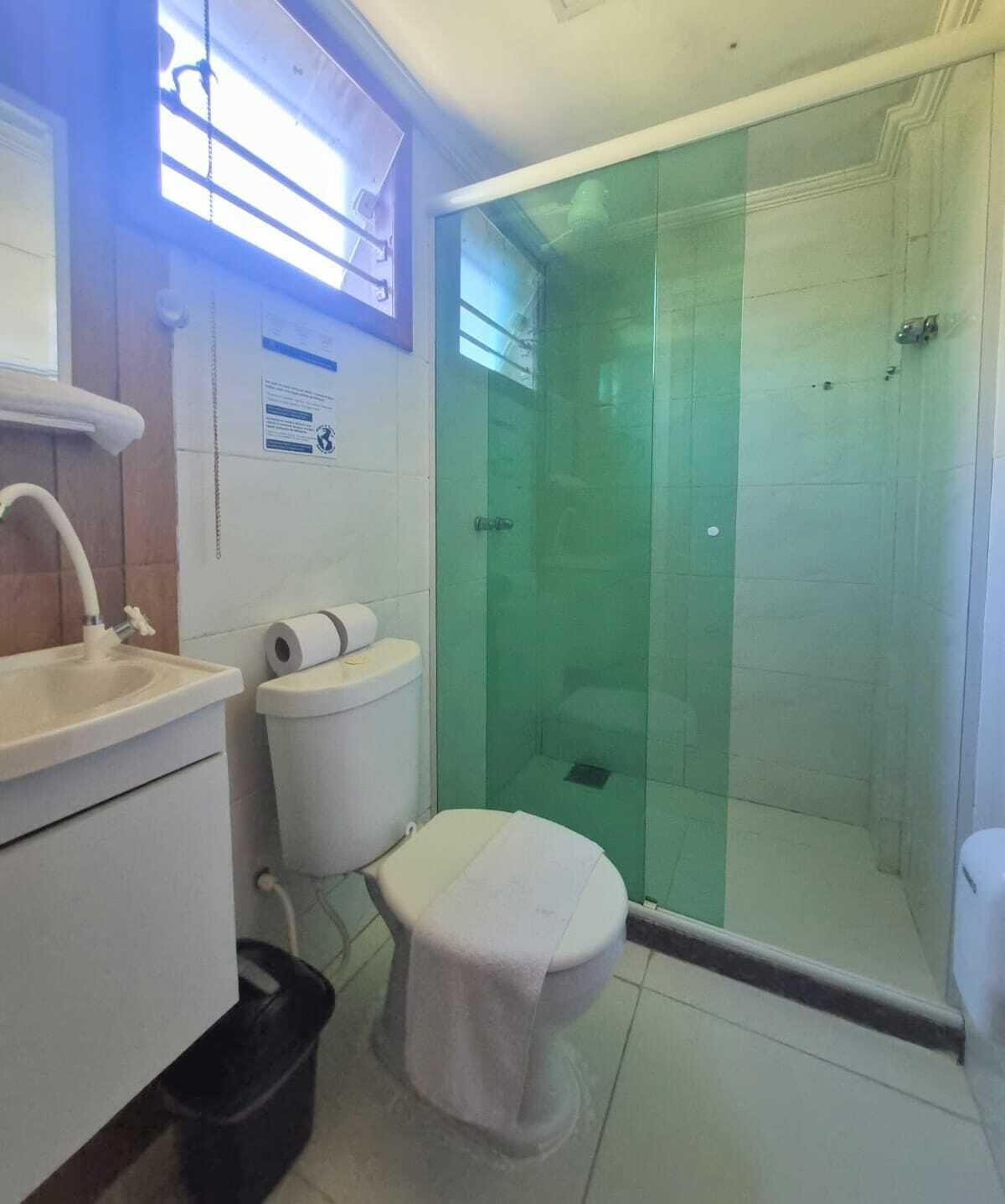 Een badkamer met toilet, wastafel en een douchecabine.