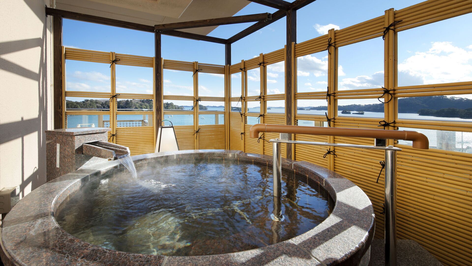 A hot tub with a view of a lake and mountains.