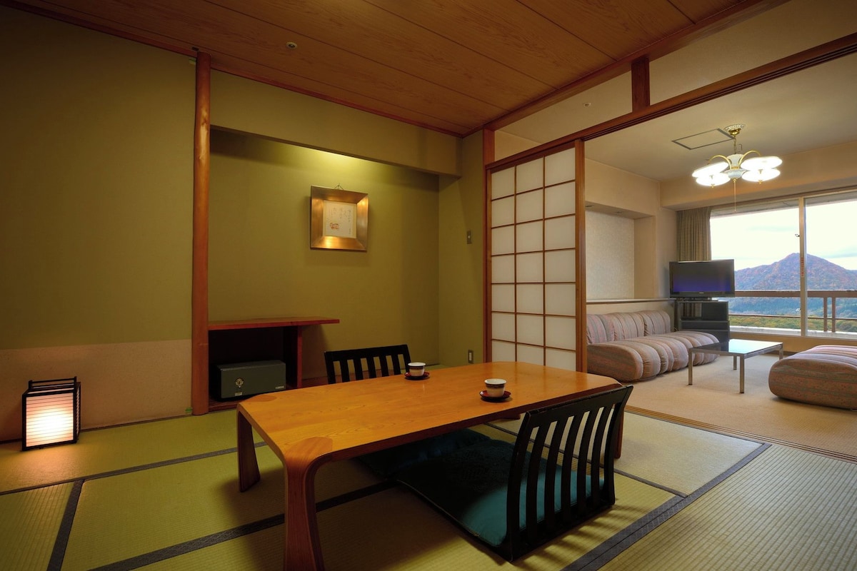 A traditional Japanese-style room with tatami flooring, a low table, and a sofa.