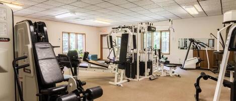 Ein Fitnessstudio mit verschiedenen Trainingsgeräten, darunter Kraftgeräte und Cardiogeräte.