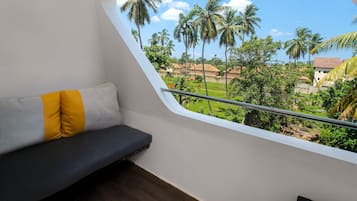 Un balcón con vista a palmeras y casas.