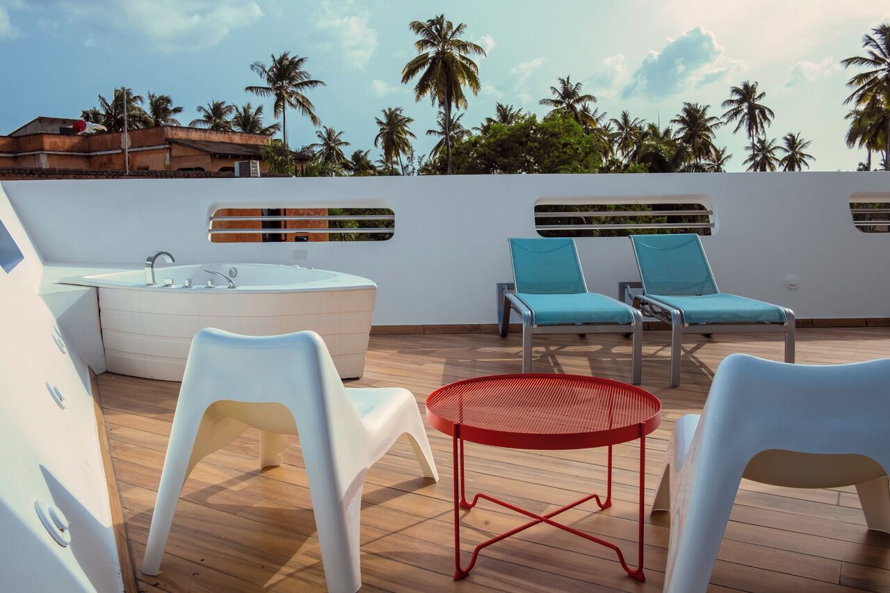 Eine Dachterrasse mit Whirlpool, Liegestühlen und einem kleinen Tisch.