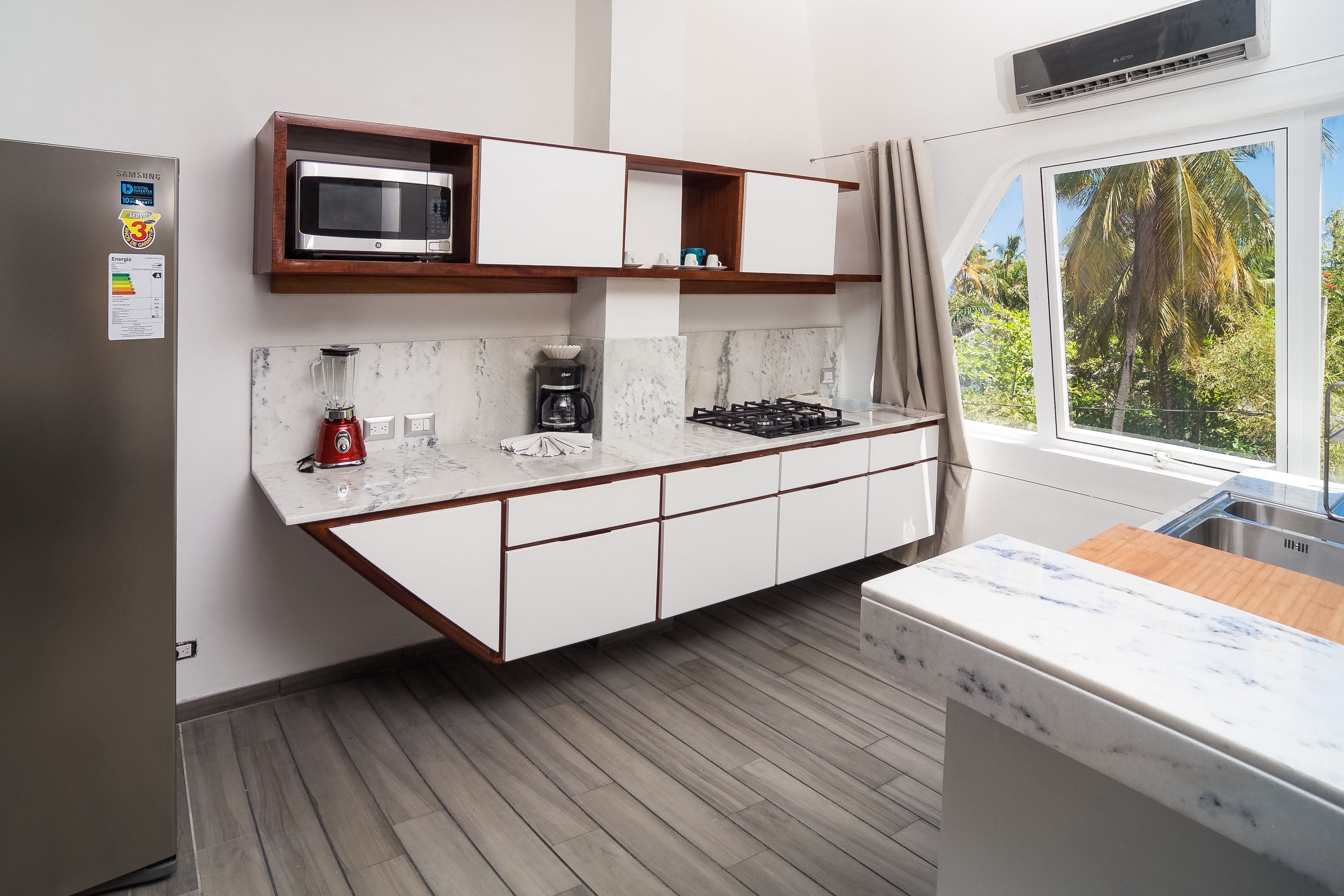 A modern kitchen with a built-in microwave, a coffee maker, and a gas stove.