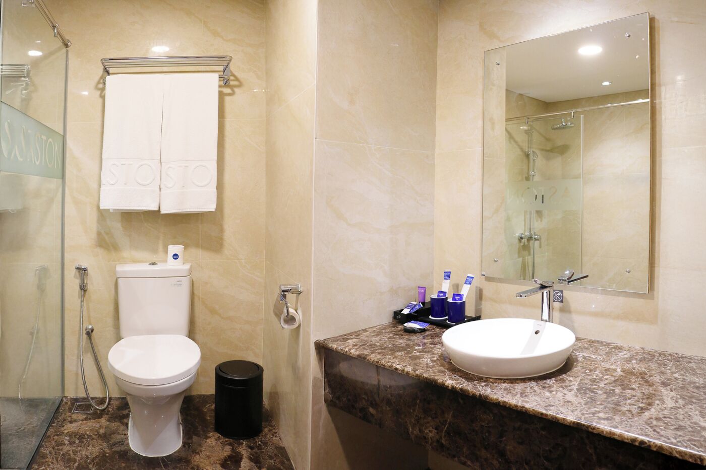 A bathroom with a toilet, bidet, and a sink with a mirror.