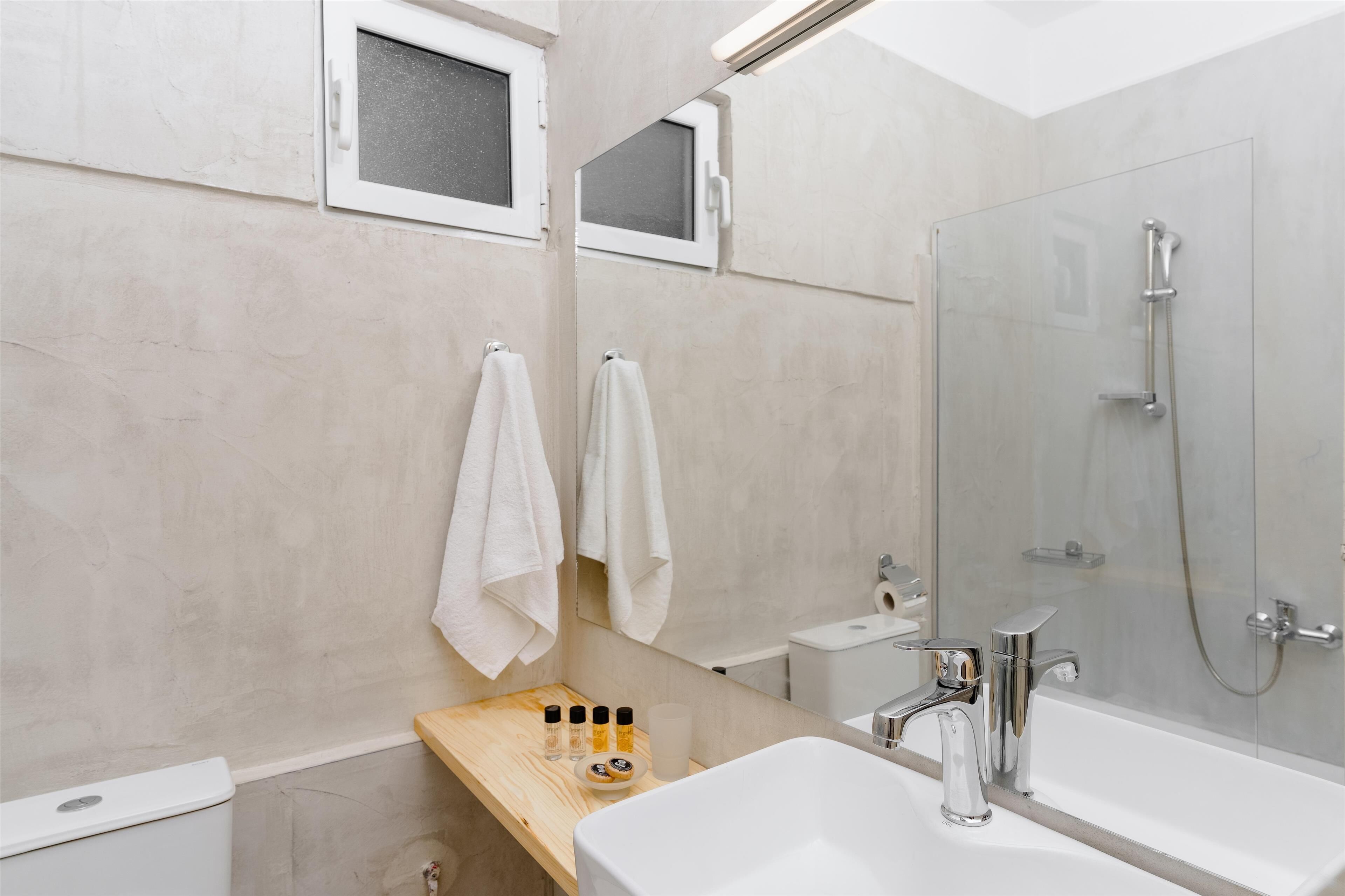 Une salle de bain moderne avec une douche à parois de verre, un lavabo blanc et un meuble-lavabo en bois.