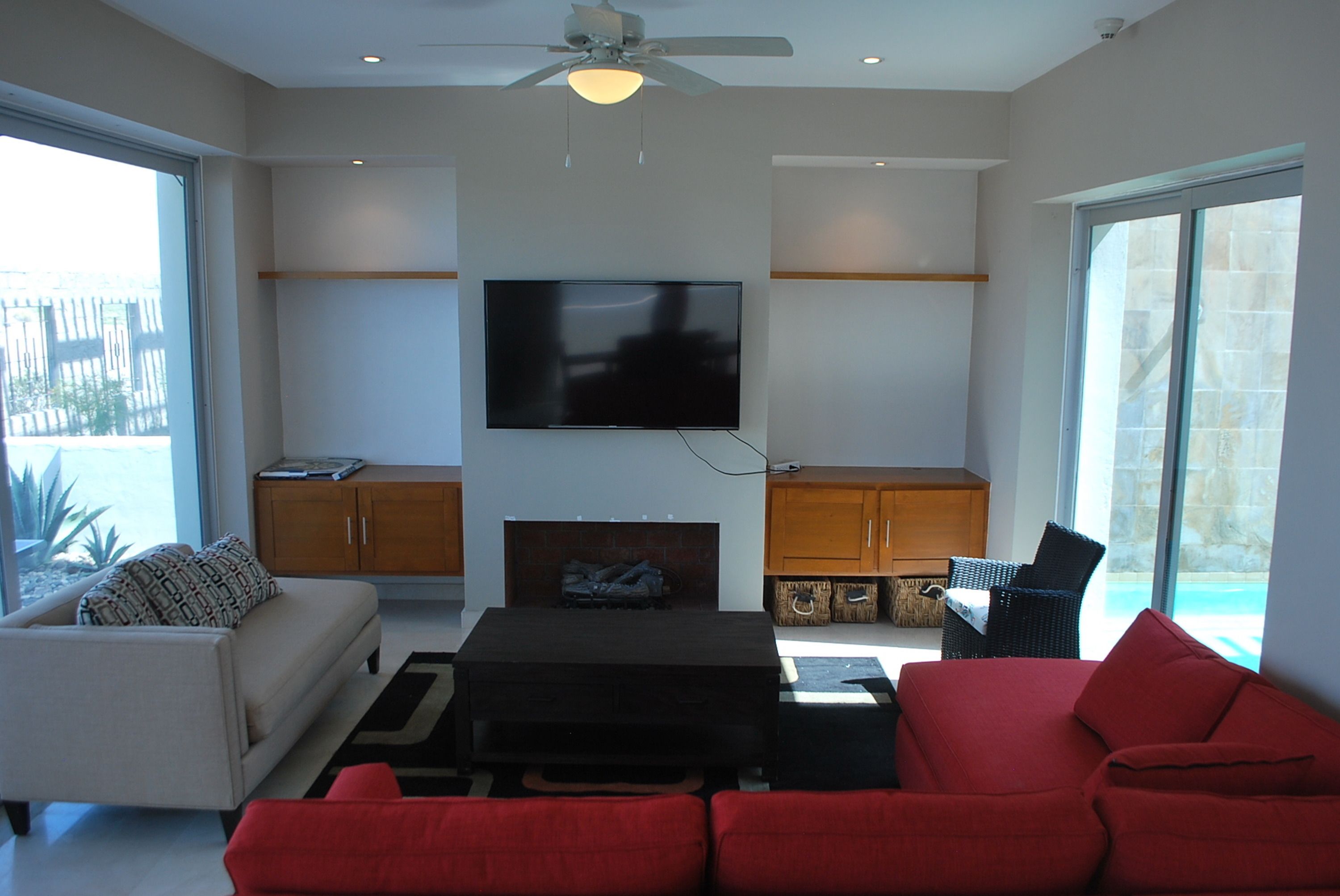 Una sala de estar moderna con una televisión de pantalla plana, una chimenea, un sofá y una zona de comedor.