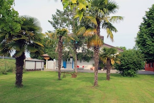 Zona residenziale con palme, un edificio bianco con una porta blu e un edificio rosso sullo sfondo.