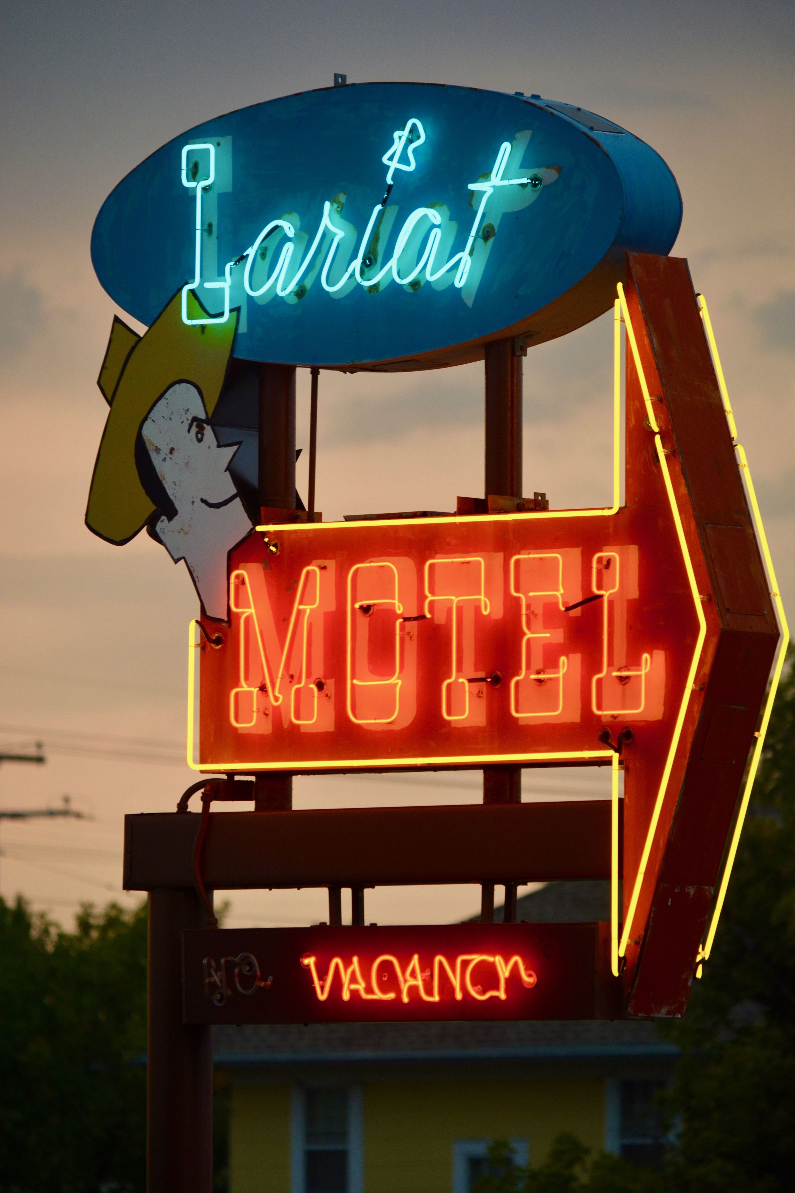 Motellin kyltti, jossa on neonvalot, mukaan lukien neonkyltti, jossa lukee ”Lariat” ja ”VAPAA HUONE”.