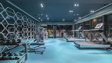 A modern gym with treadmills, dumbbells, and weight machines.