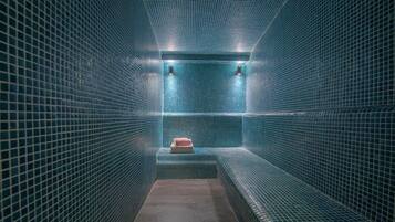 Bathroom features a geometric tile pattern and a bench for relaxation.