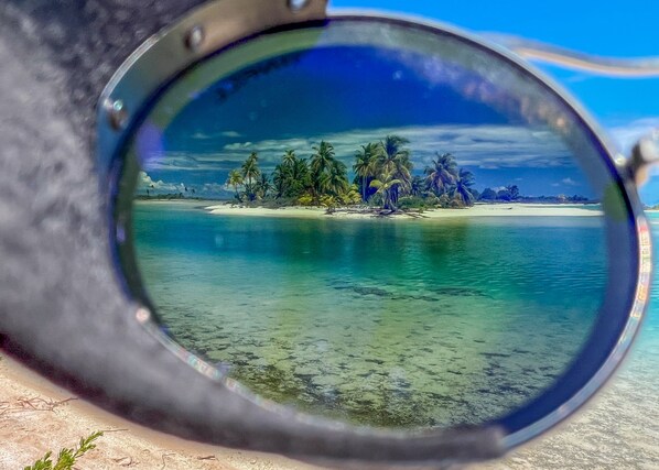 A tropical island with clear turquoise waters and palm trees. - Ninamu Resort (Tikehau)