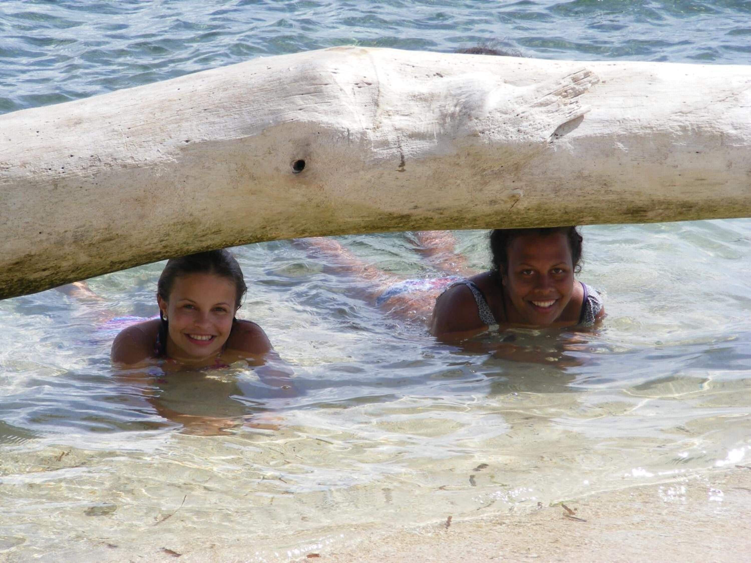 Dos personas en una zona poco profunda con una roca grande sobre ellas.