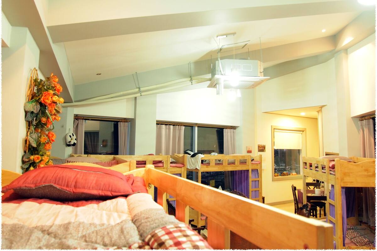 A room with a bunk bed, a desk, and a chair.