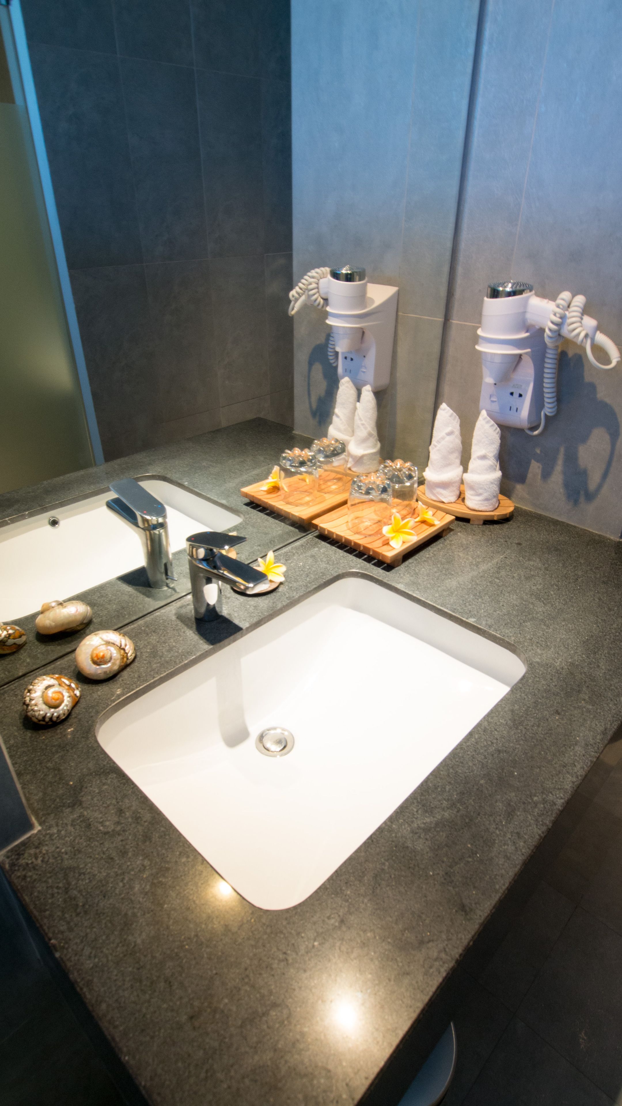 A bathroom with two sinks, a mirror, and a towel rack.