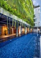 Una piscina al aire libre, sombrillas, sillones reclinables de piscina