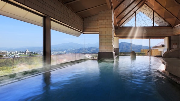 A hot spring area with a view of mountains and a cityscape.