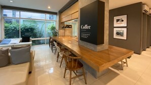 Een moderne keuken met een houten bar, een groot raam en een bord met de tekst 'coffee'.