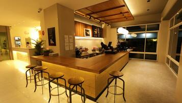 A modern kitchen with a central island, bar stools, and a large window offering a view of the outdoors.