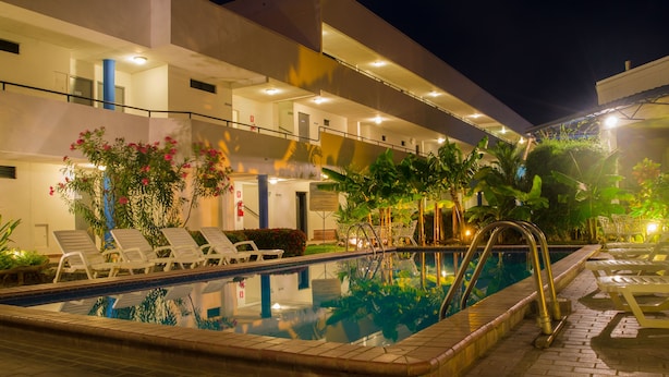 Una piscina al aire libre, tumbonas