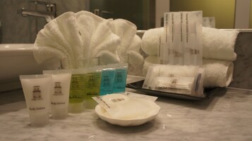 Toiletries and towels on a bathroom counter.