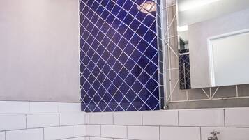 Een badkamer met toilet, wastafel en een blauwe betegelde muur.