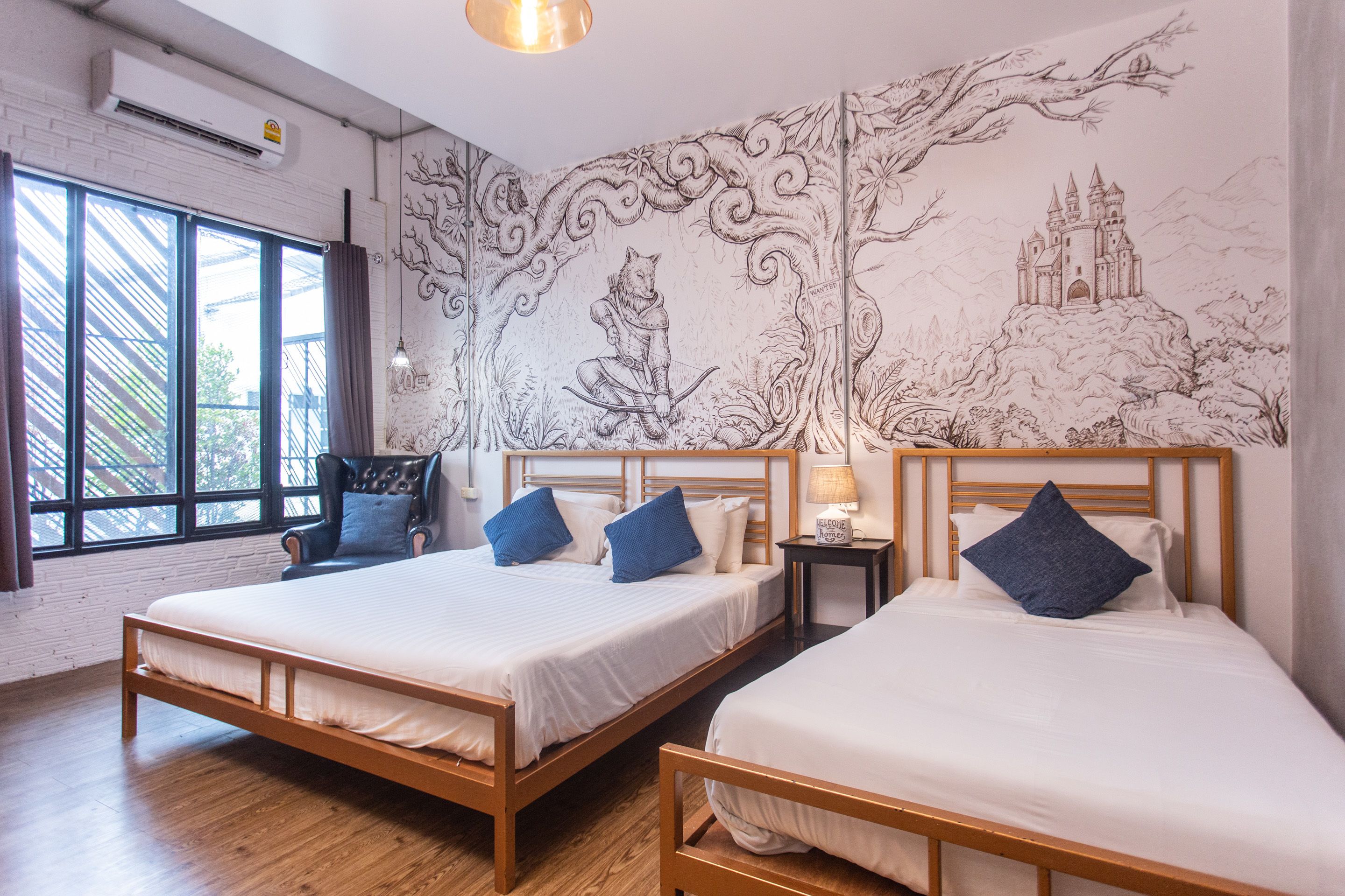 Habitación de hotel con dos camas, un ventanal grande y un mural en la pared.